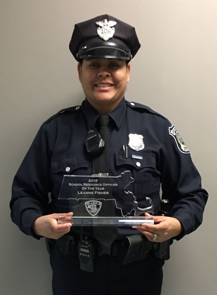 Officer Leanne Fisher holding a 2016 School Resource Officer Of The Year Award in her outfit.