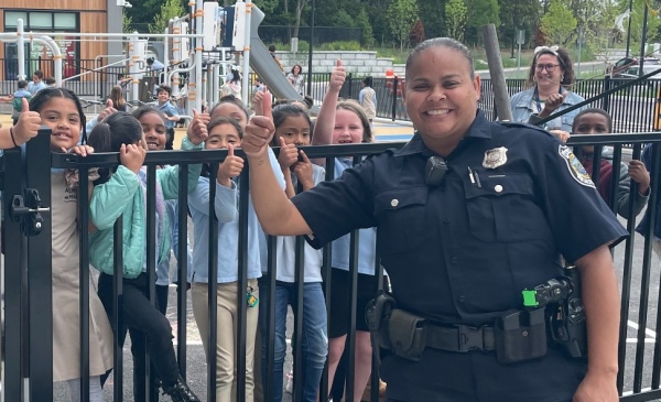 Officer Leanne FIsher giving the best thumbs up the world has ever seen in front of a crowd of children.