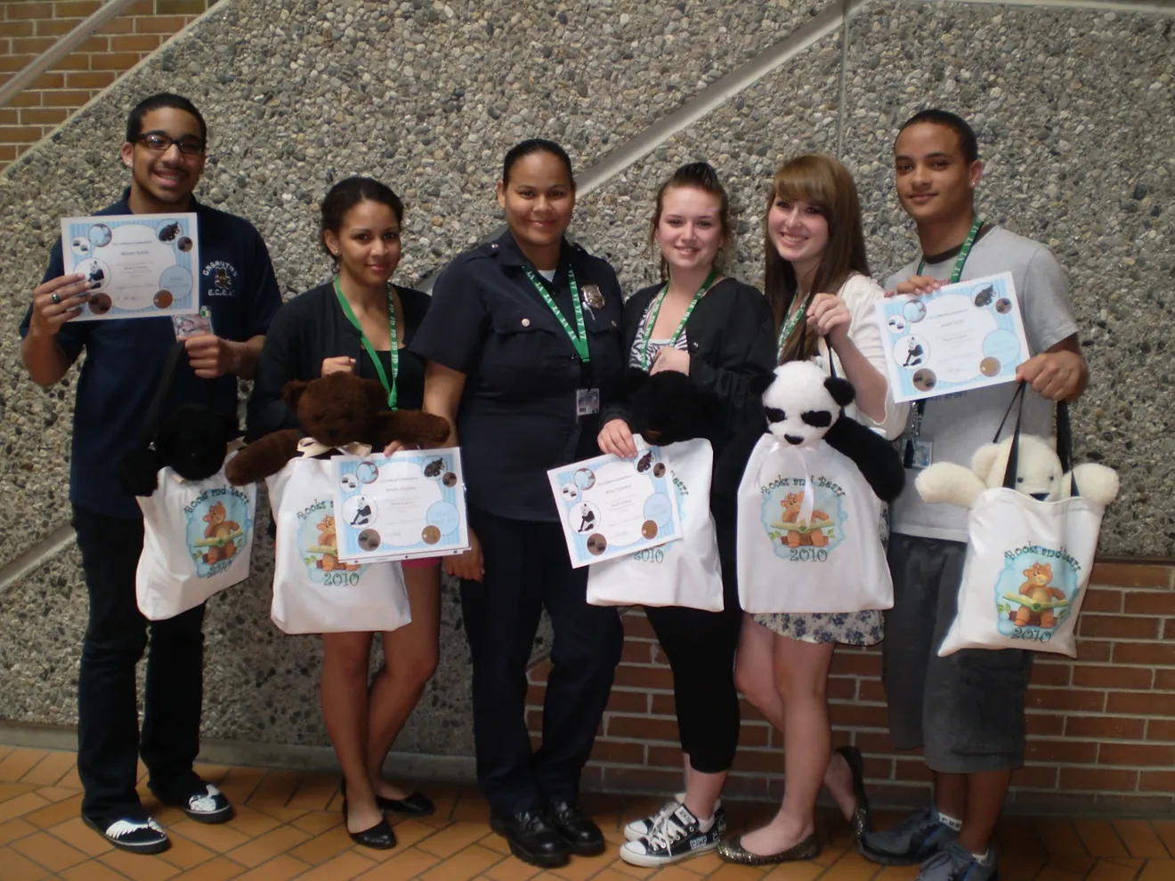 Officer Leanne Fisher with several students with signs looking extra cool.