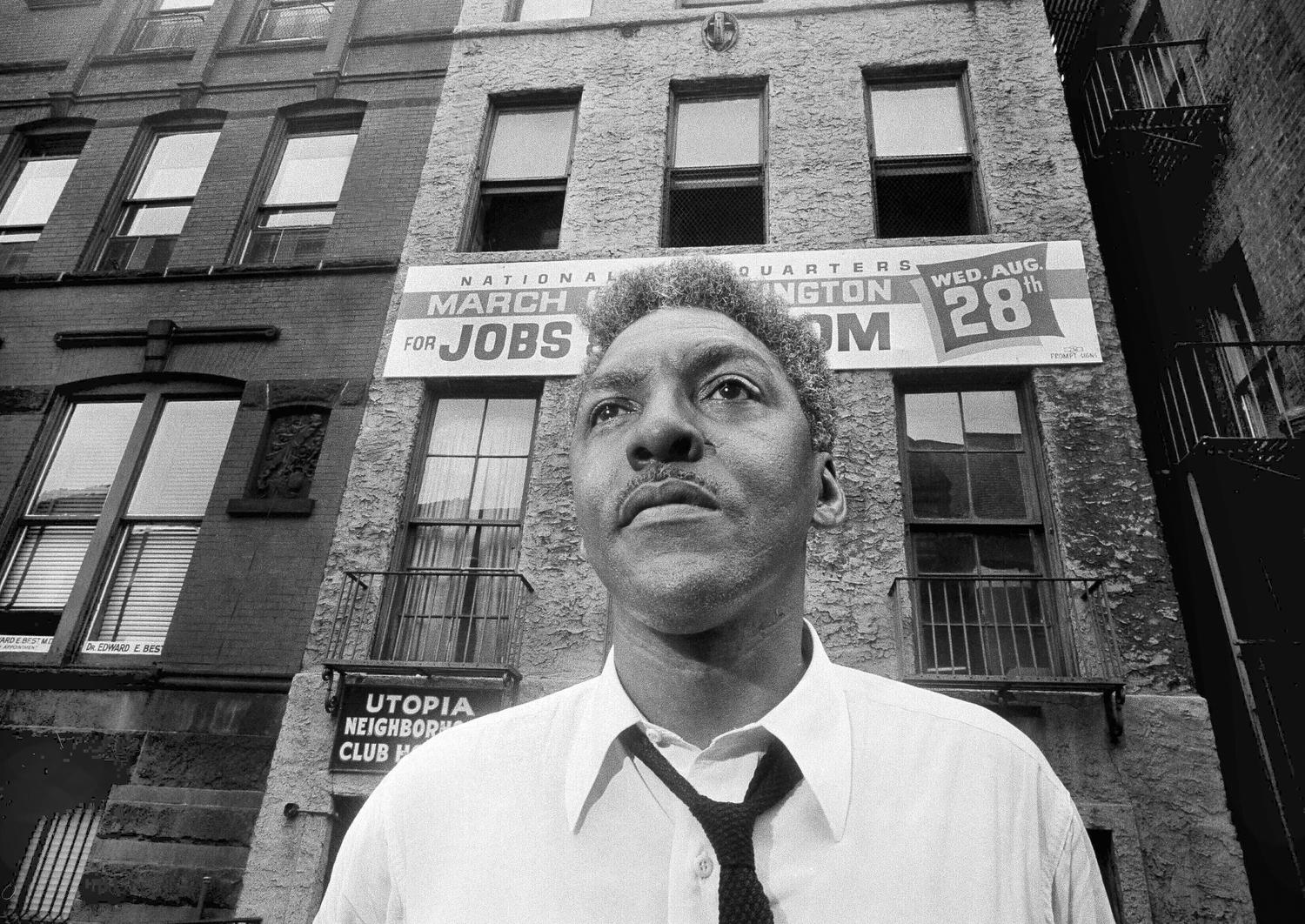 Bayard Rustin Portrait next to building with sign Marching for jobs. GSA spotlight