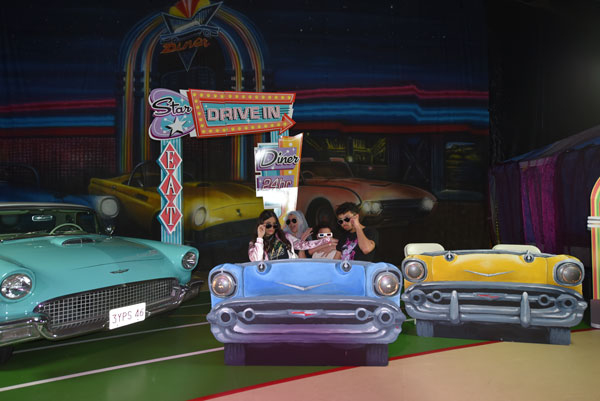 friends taking a group photo with the drive in diner backdrop at the 2024 afterprom