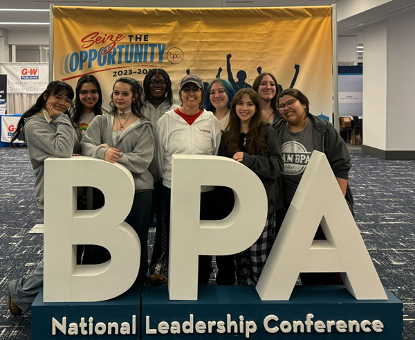 BPA National Leadership Conference Sign and Students with Advisor