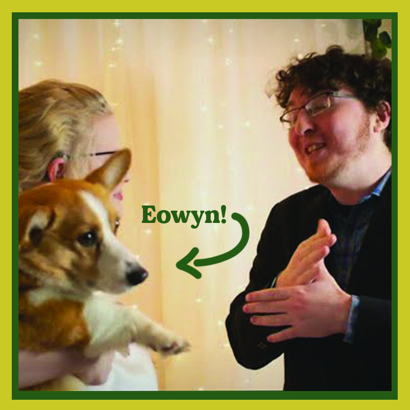 Image of Emily and Derek Cassese. Emily is holding their corgi, Eowyn as Derek communicates with Emily using sign language.