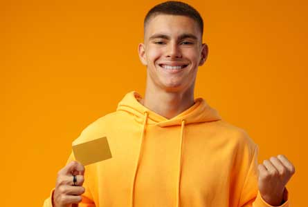 Student smiling wearing all yellow with a gift card