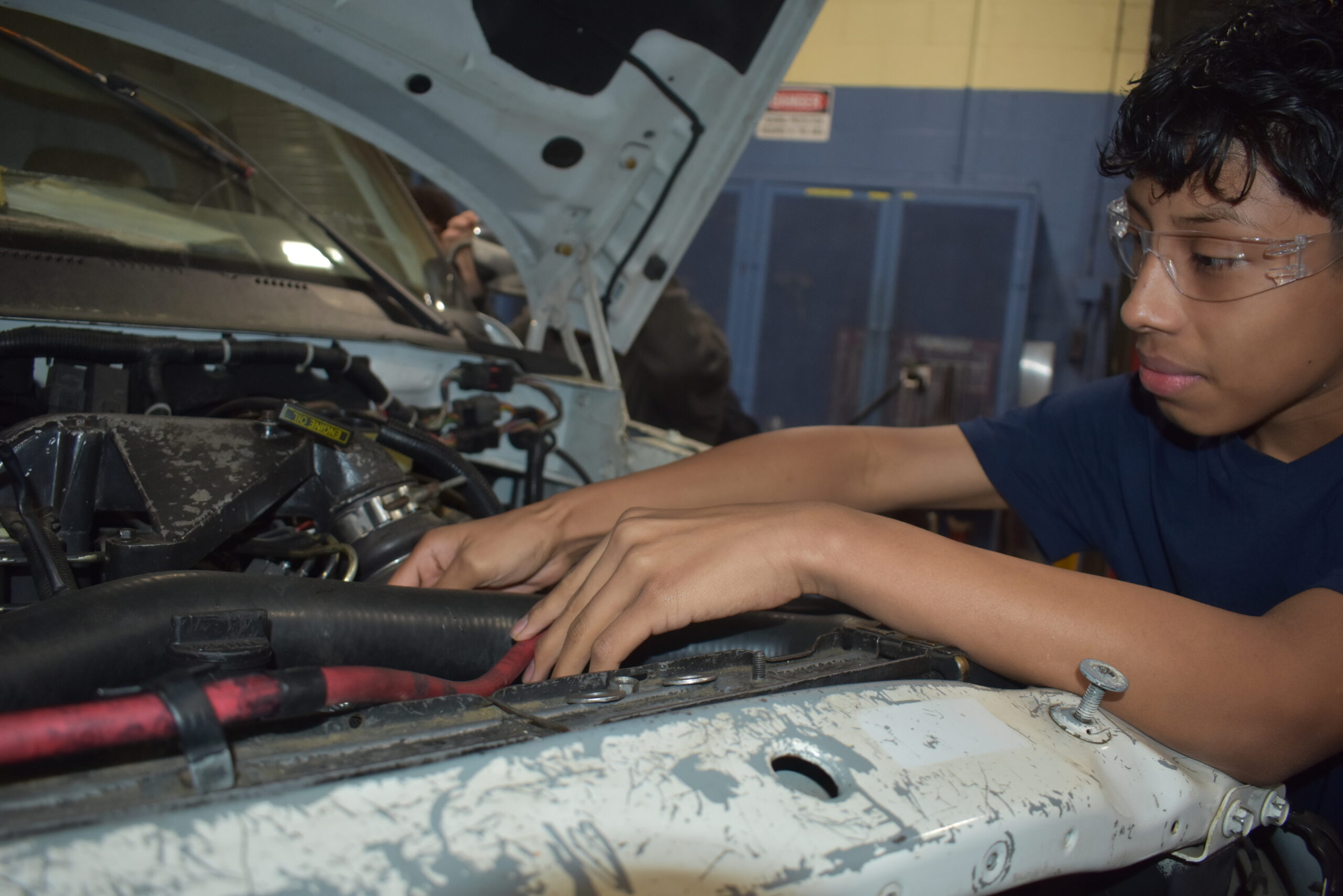 Student working within a truck engine