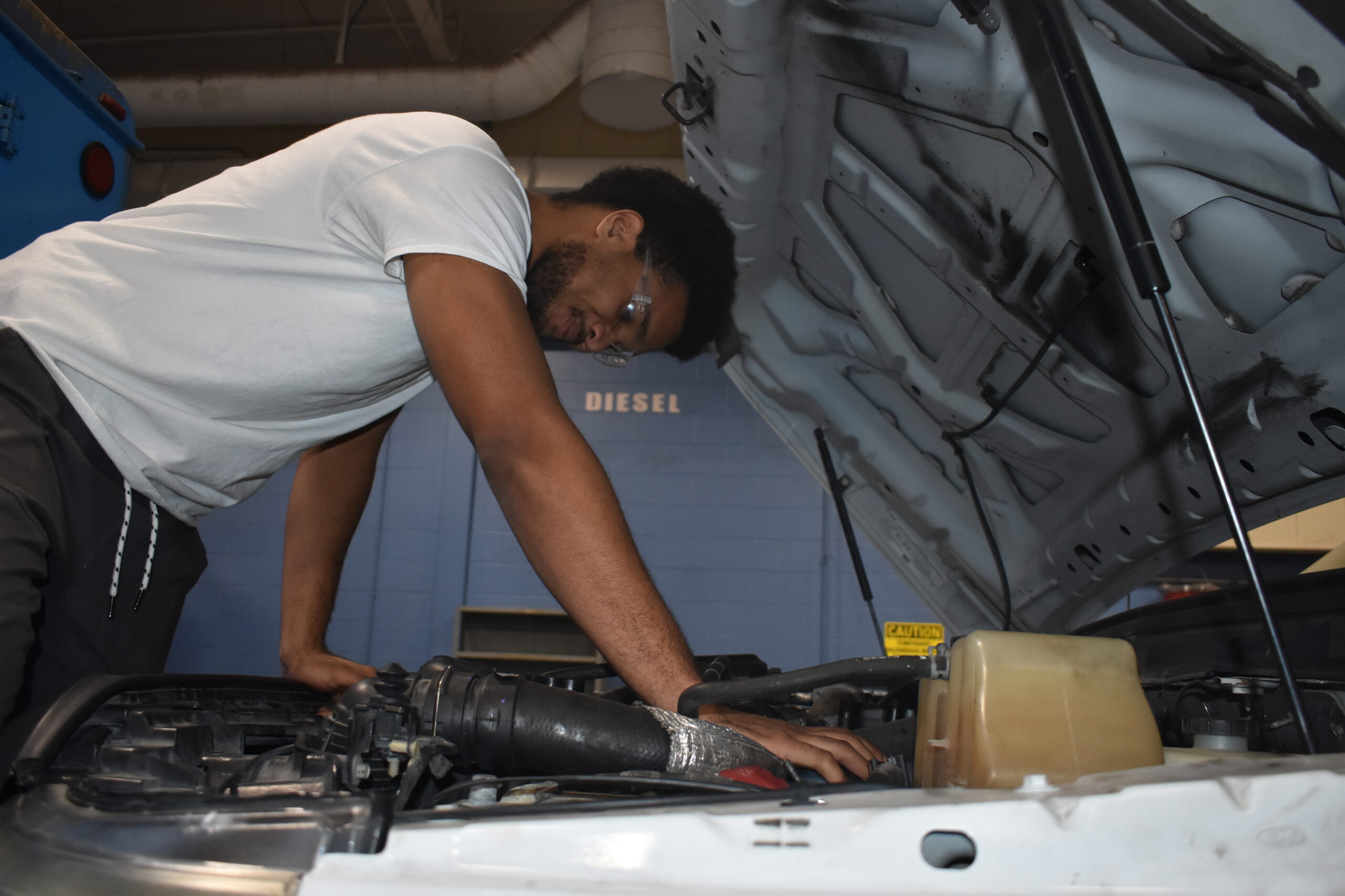 Student working on engine of a truck 