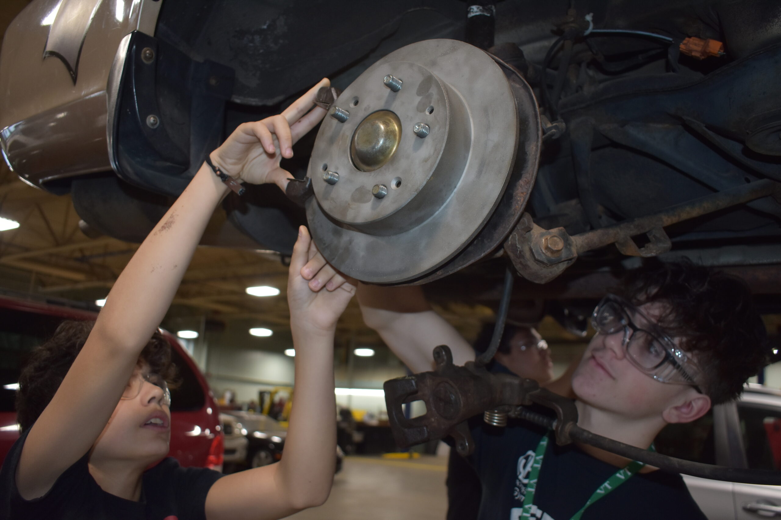 Two students working on a car part<br />
