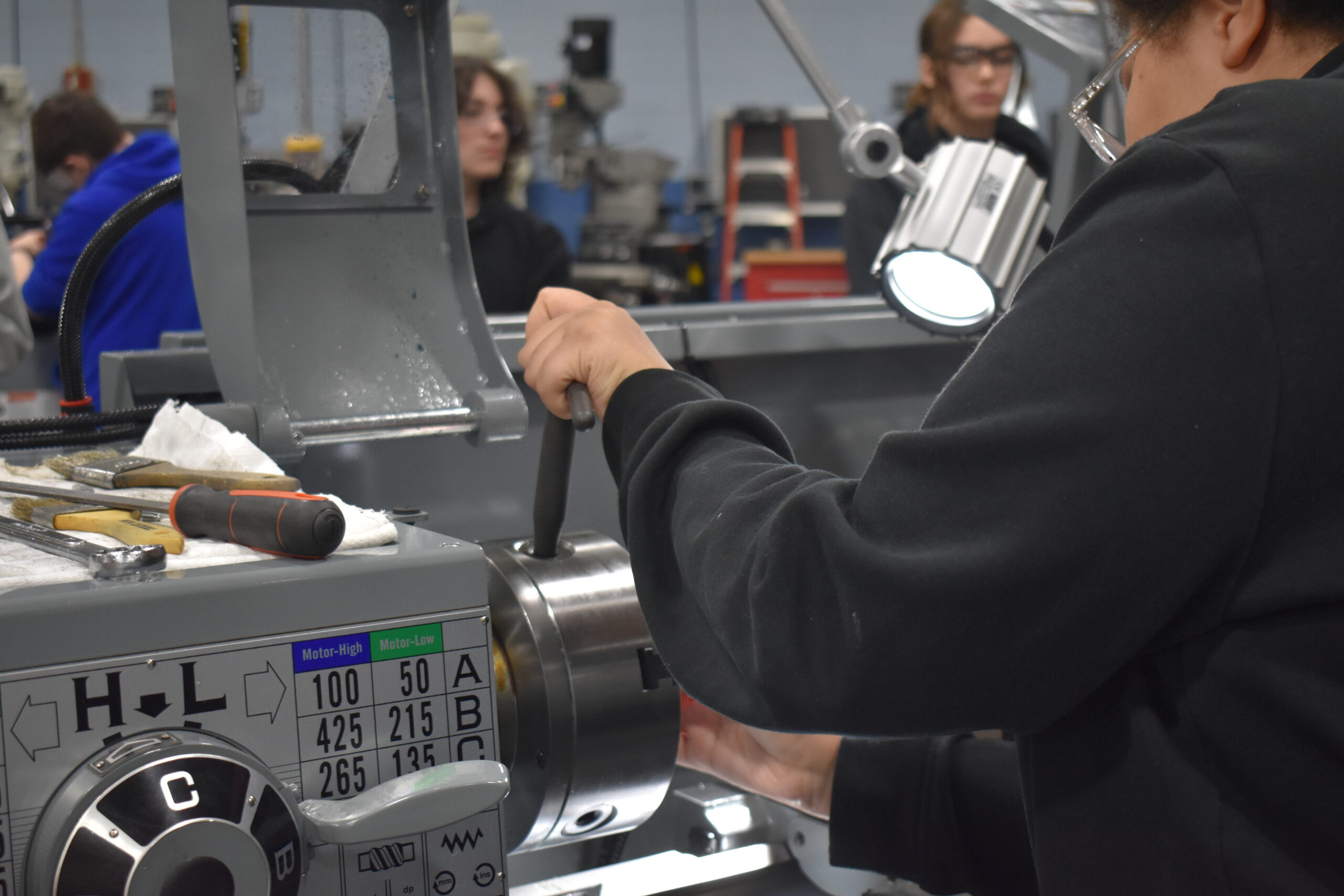 Student using a mechanism on a machine