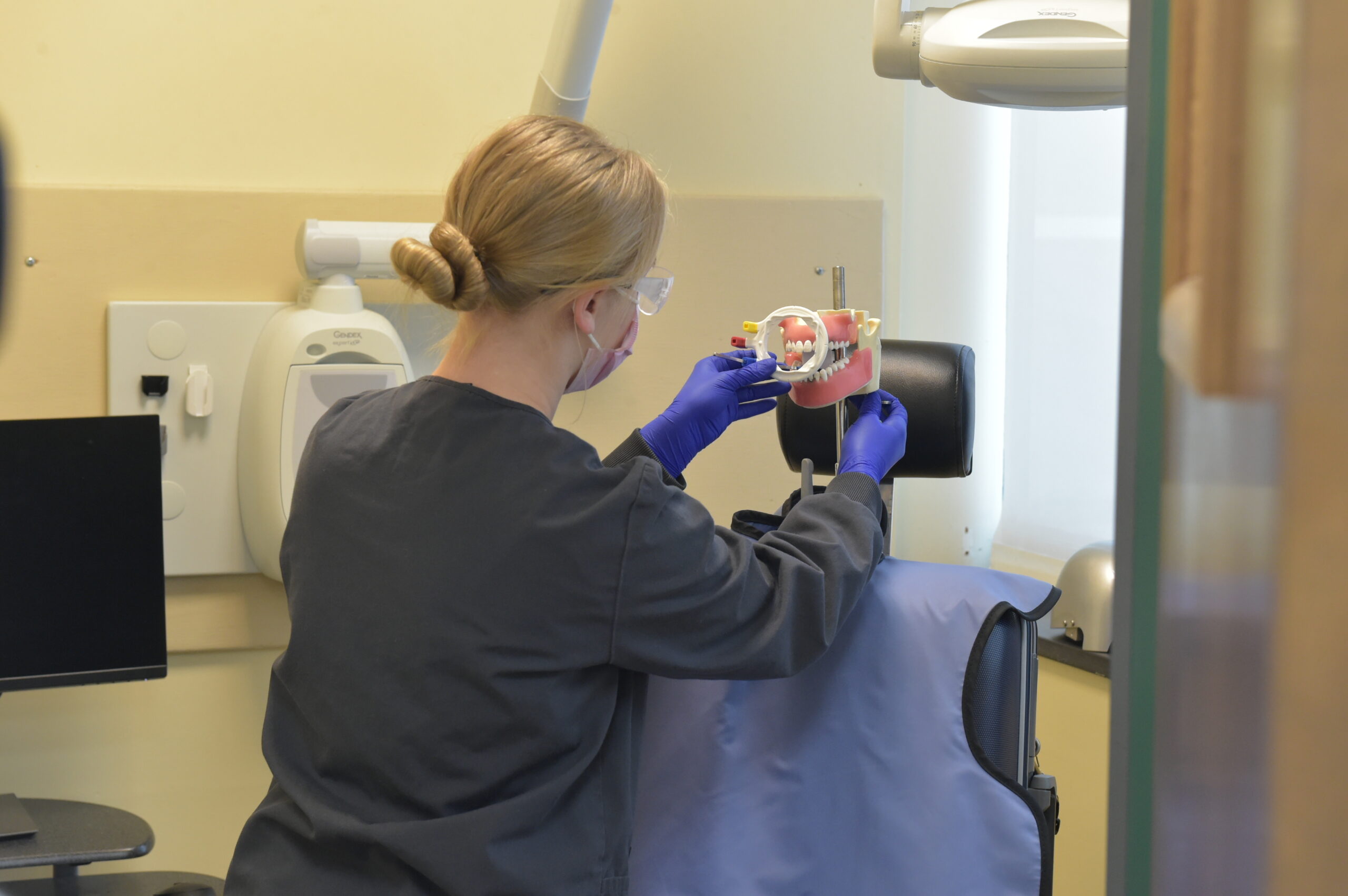  Student placing x-ray film holder in the manikins mouth to take an x-ray 