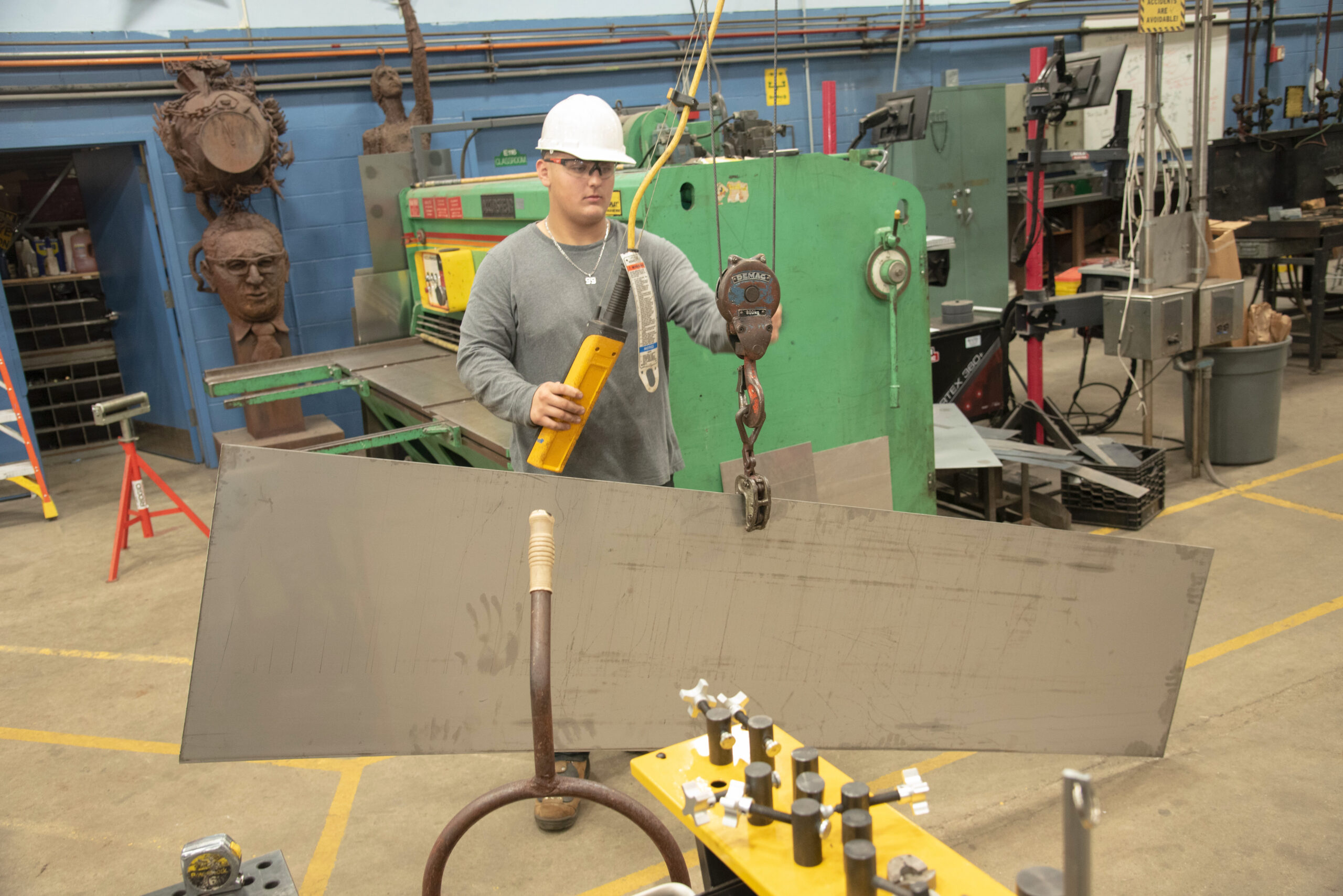 Metal Fabrication student moving metal sheets