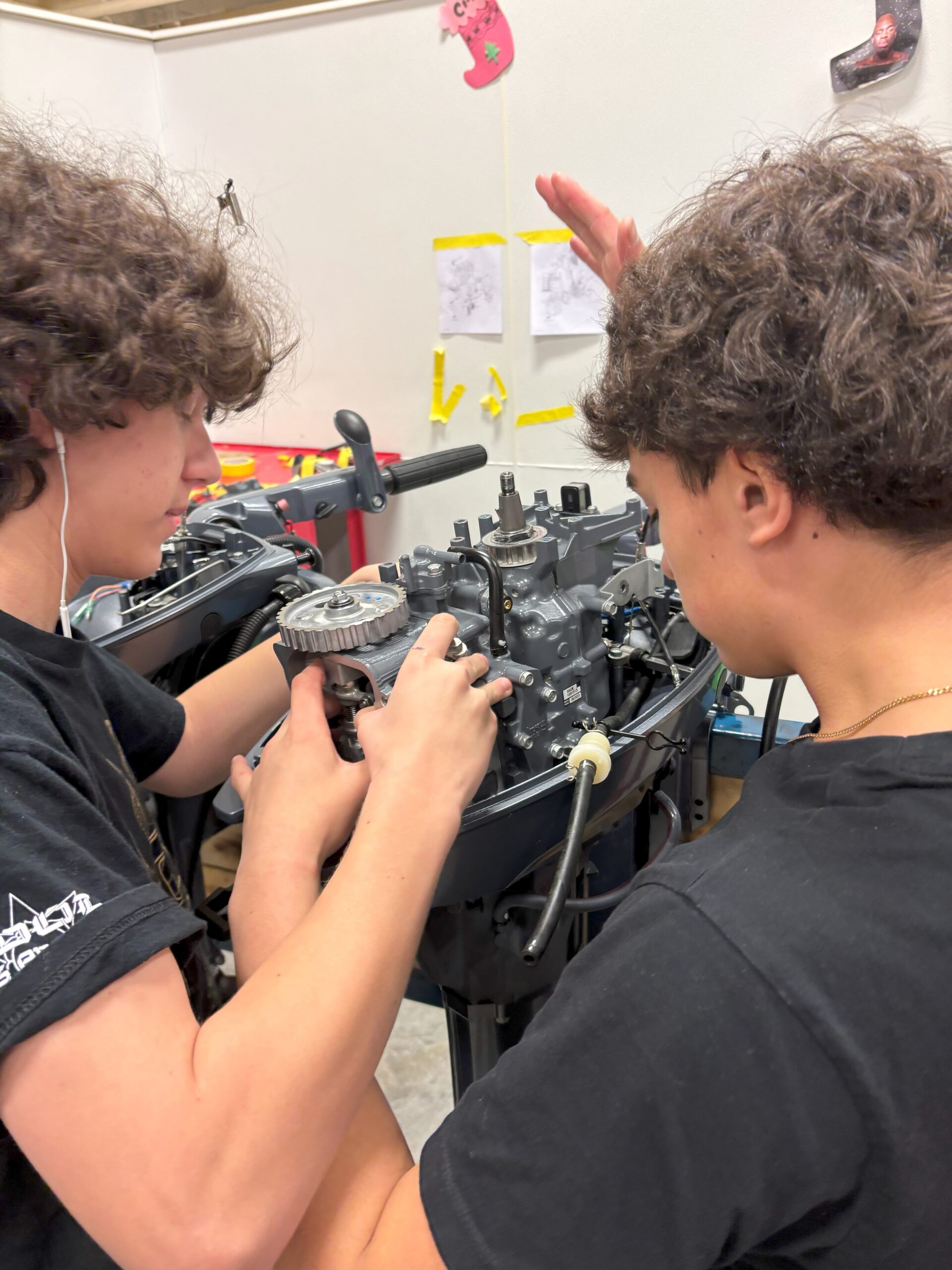 Students working together on a boat piece