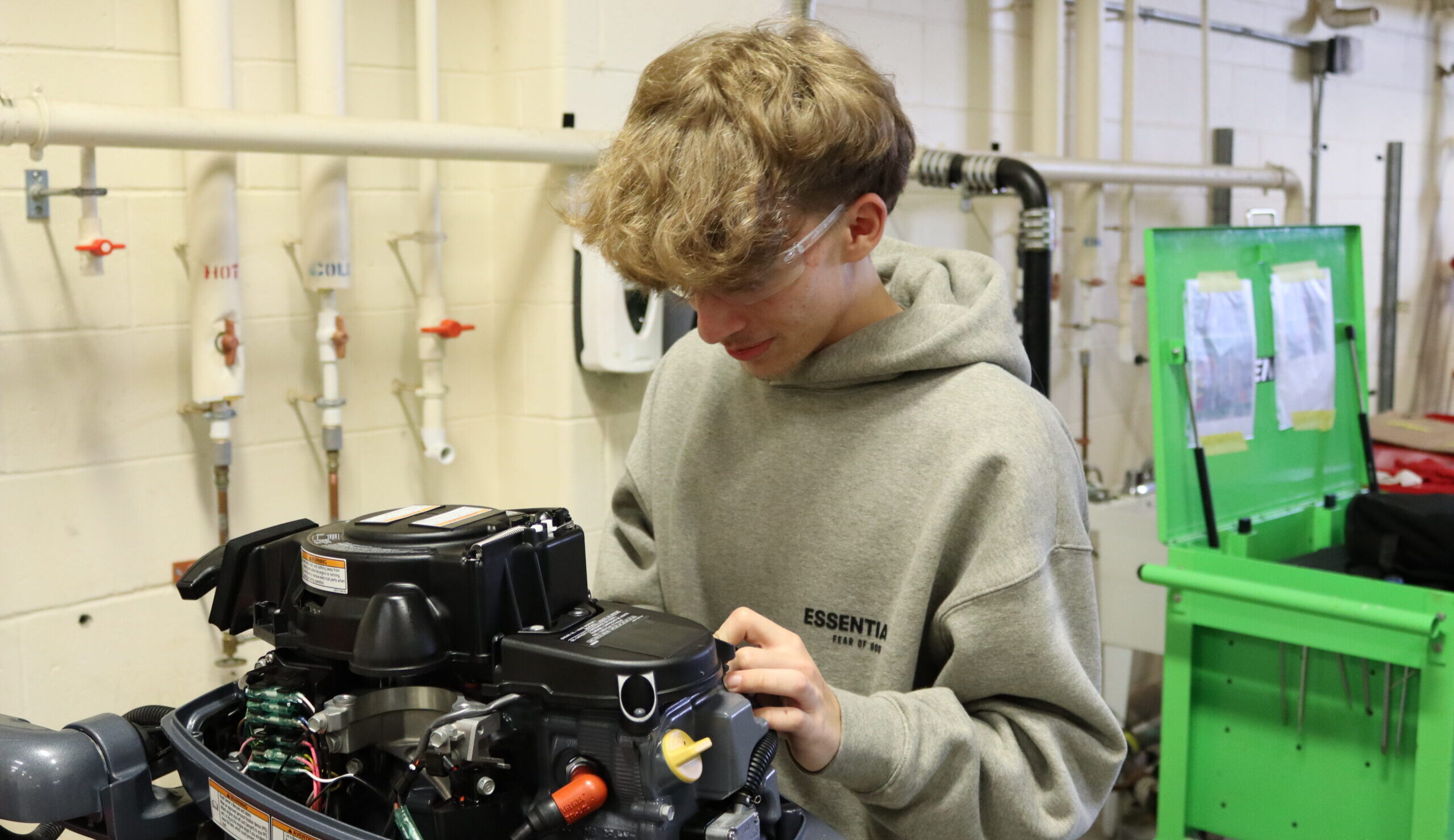 A student carefully working on  a part