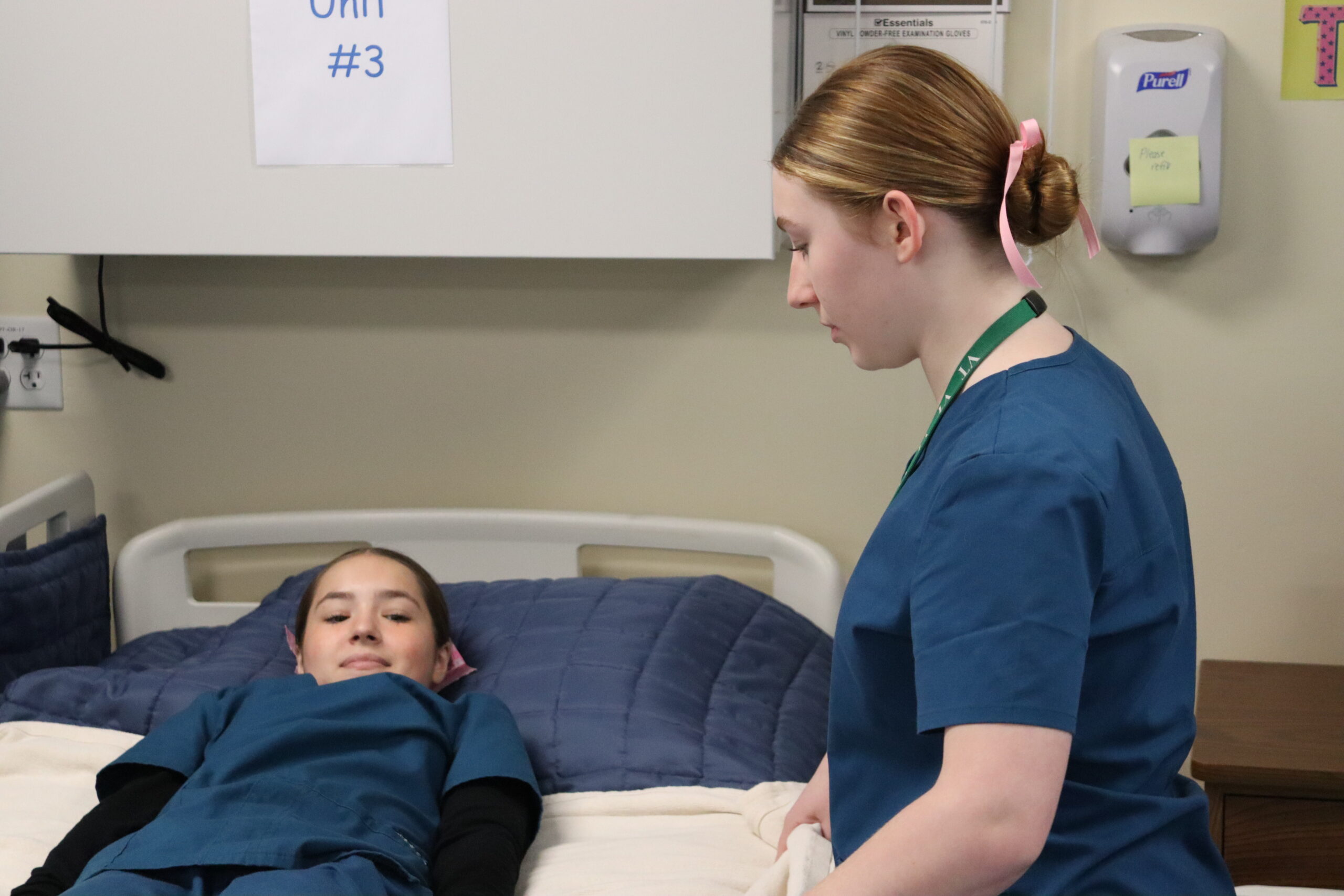 nursing student getting patient in bed