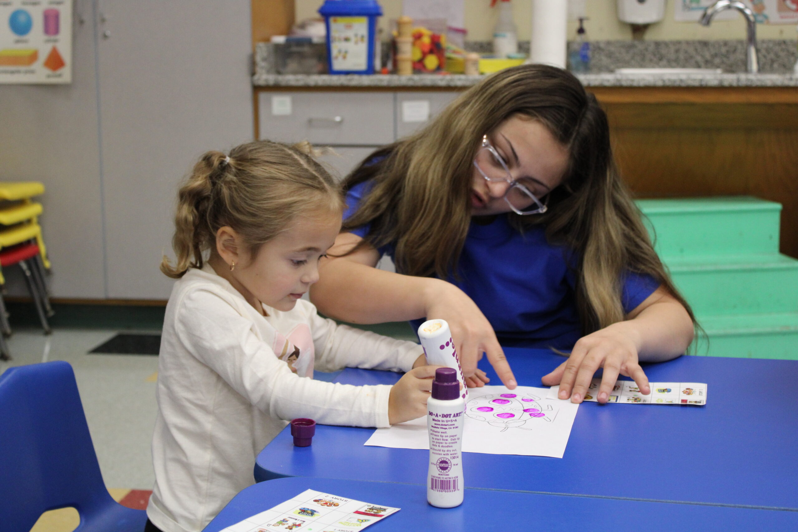 Early Childhood student helping a child with a project<br />
