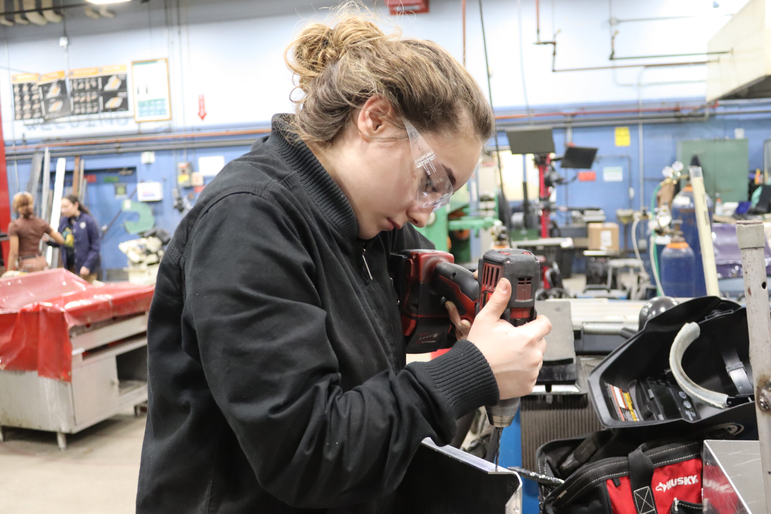 Metal Fabrication student using drill to create holes in metal