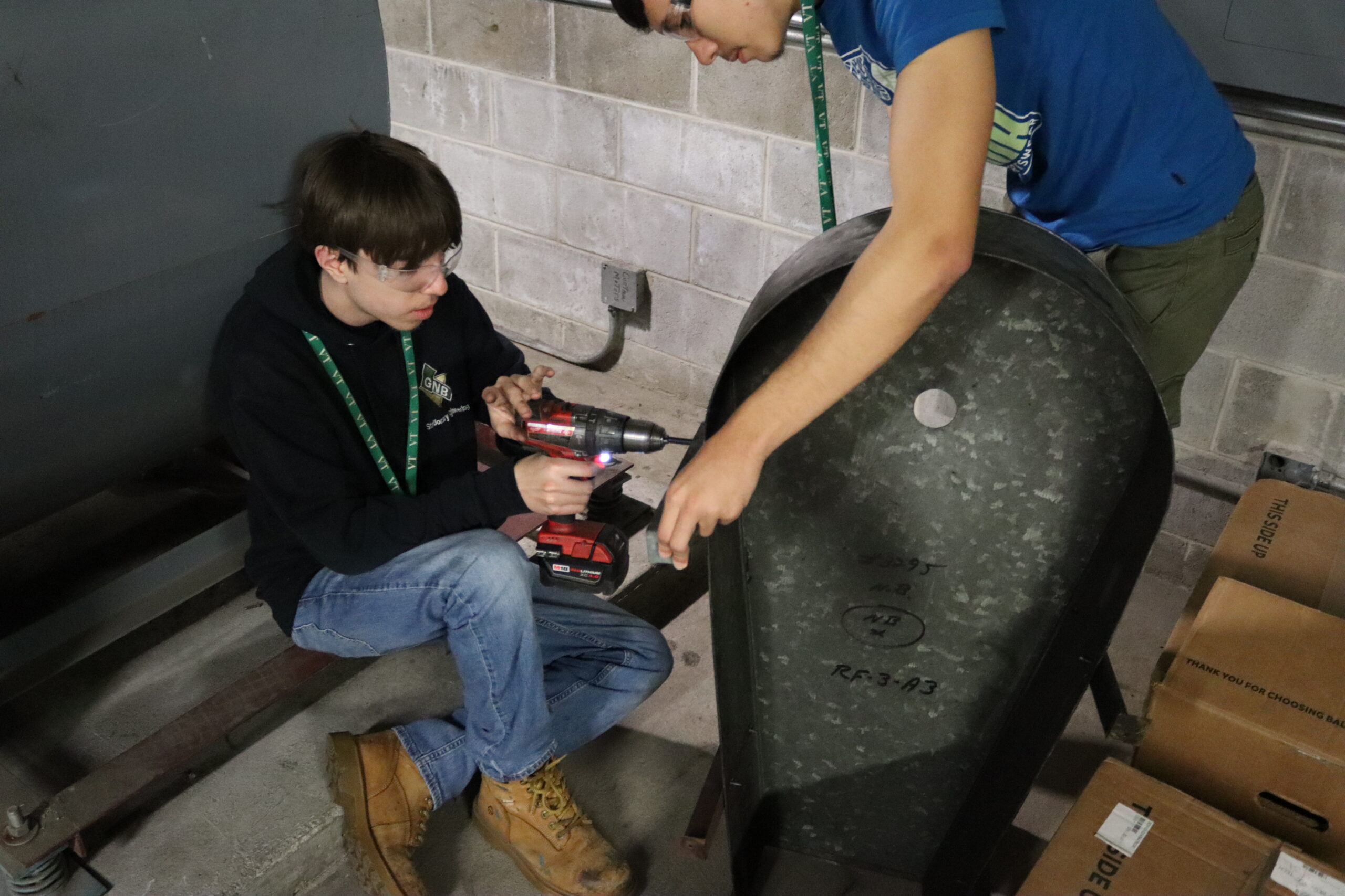 STEAM Students installing the belt guard shield on the AHU