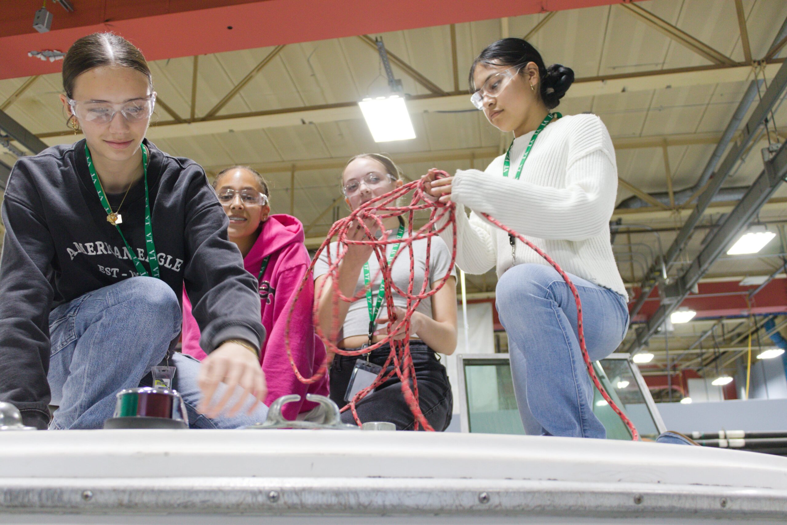 Students working together with rope and using it on a certain part.