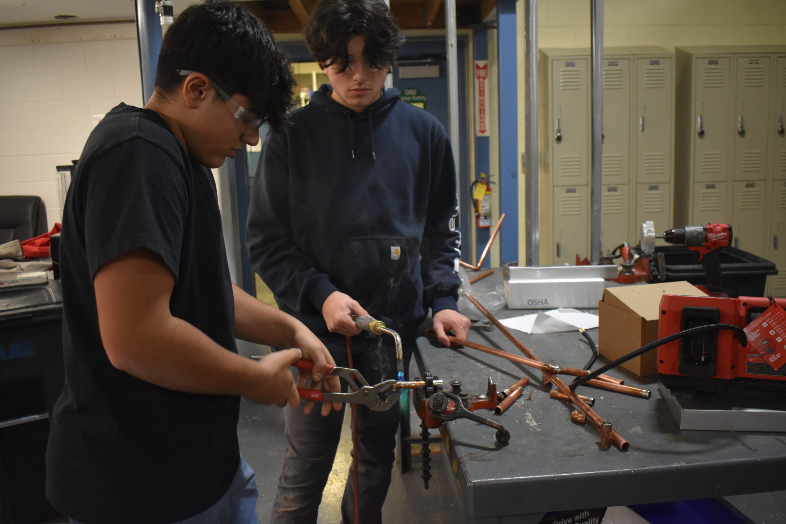 Two students working together with a torch