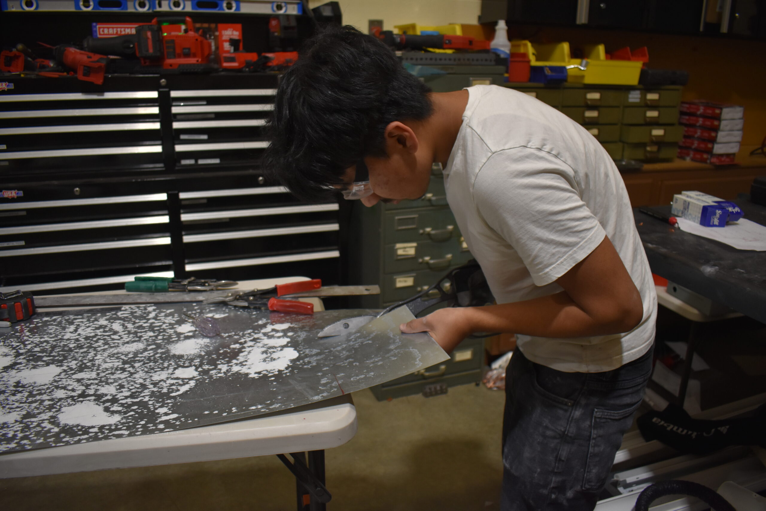 Student cutting a metal sheet