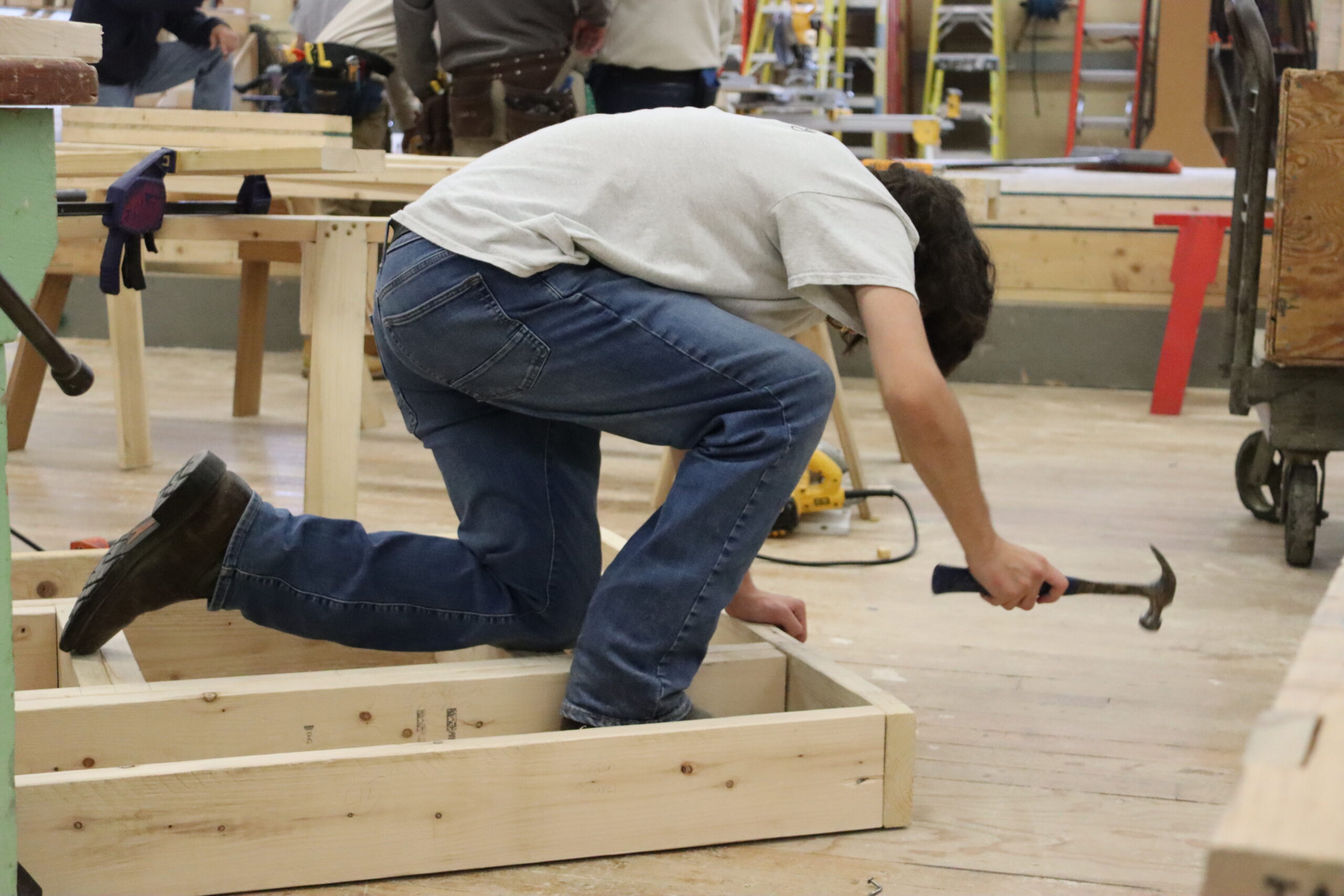 Carpentry shop wide shot with student working in the background 