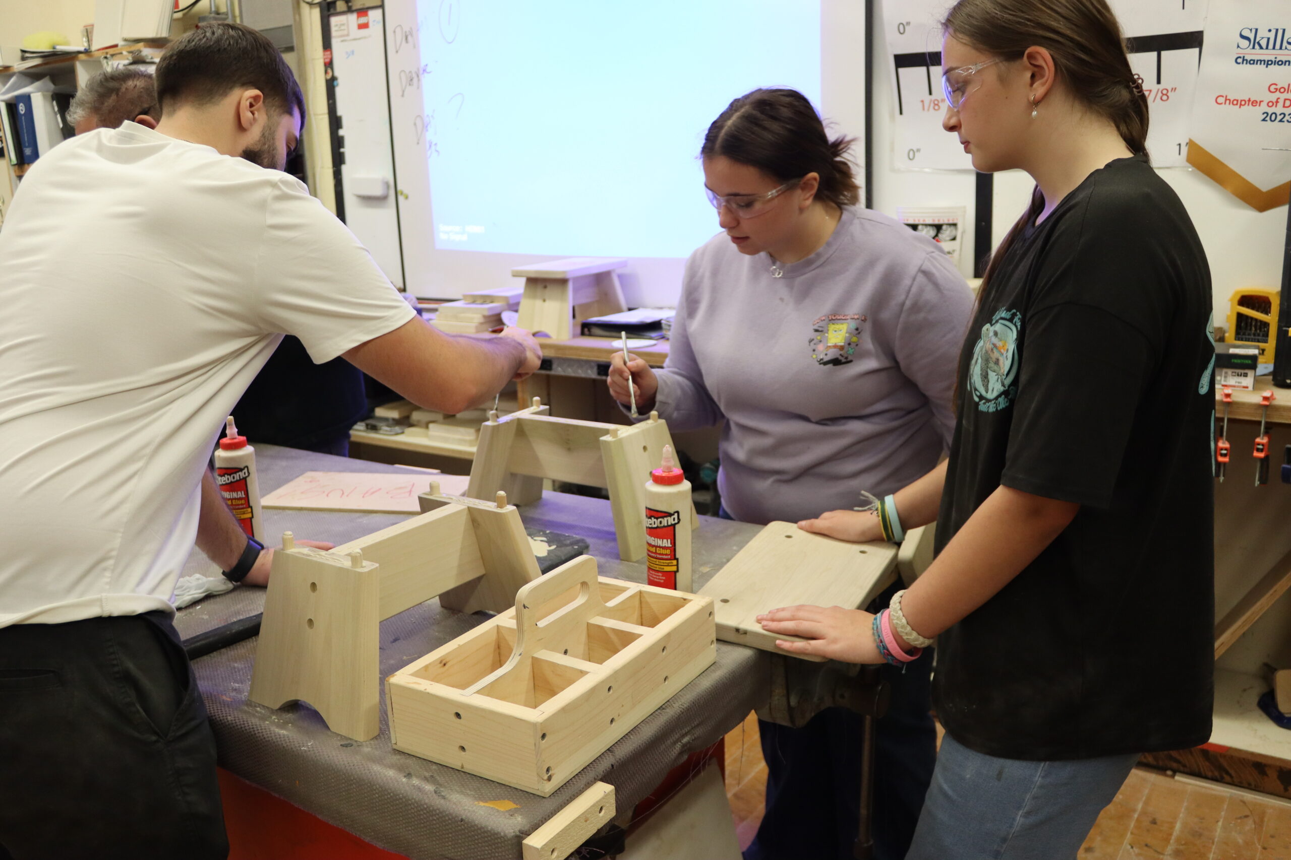 Carpentry Student using a crowbar to pry out staples