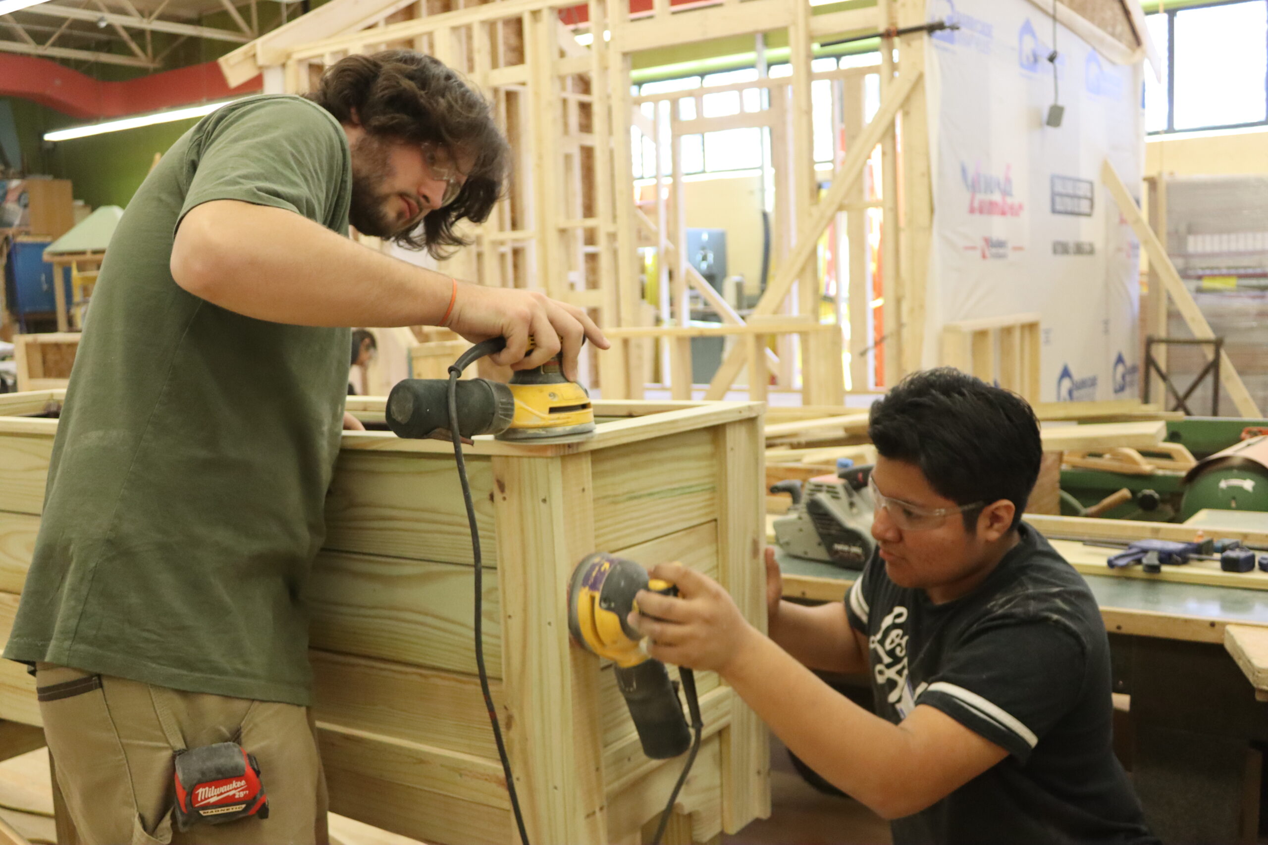 Carpentry students sanding blocks of wood